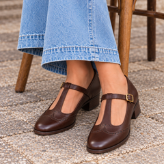 Detalle de los zapatos Maddalena marrón con vaqueros, sentada en una terraza